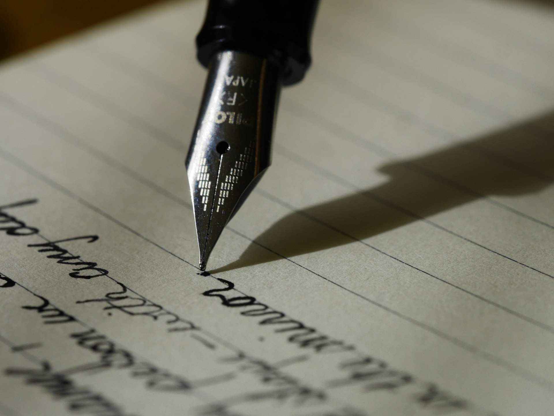 Fountain pen writing on paper, editorial desk detail