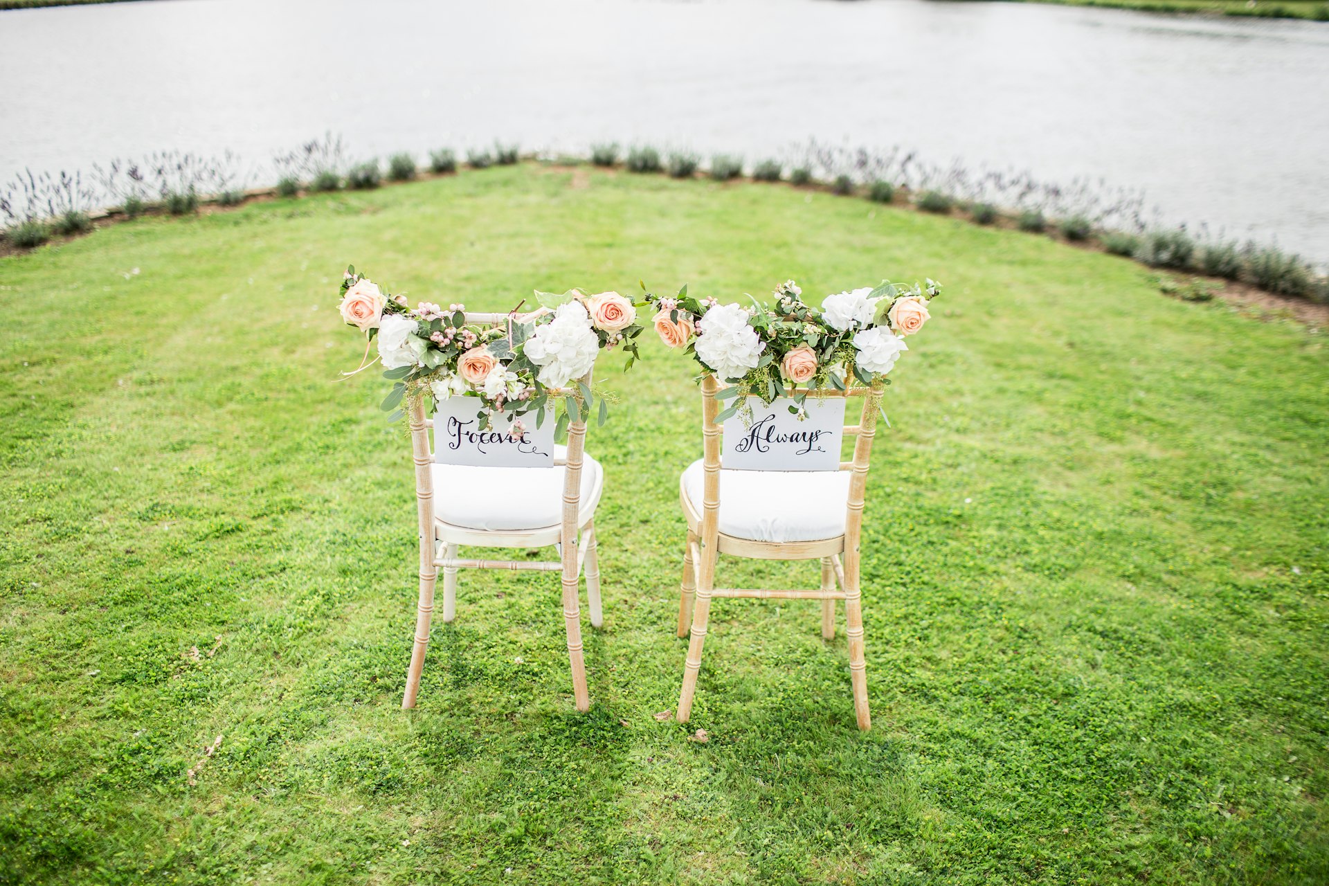 Outdoor ceremony setup with floral arch and chairs